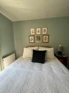Charming and cozy apartment in Pantin في بانتين: غرفة نوم عليها سرير ومخدة سوداء