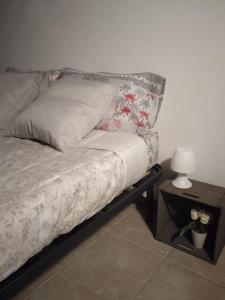 - un lit avec un oreiller et une table avec une lampe dans l'établissement Da Vale e Teo, à Legnano