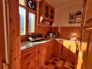 una cocina con armarios de madera y una ventana en Harmony Premium Home Stay, en Duff Dunbar