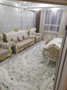 ein Wohnzimmer mit 2 Sofas und einem Bett in der Unterkunft 1комнатная квартира in Bischkek