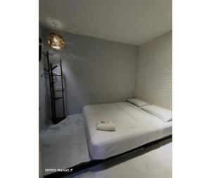 una piccola camera con un letto bianco e un asciugamano sopra di EXPRESS OYO HOTEL a Kuala Lumpur