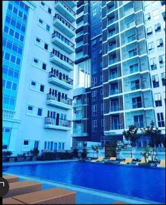 un grand immeuble avec une piscine en face de celui-ci dans l'établissement Unit 3J Signature Suites, Lafayette Megaworld, à Iloilo