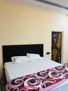 1 dormitorio con 1 cama grande y cabecero negro en The corridor inn en Calcuta