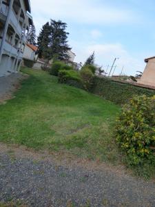 a grassy yard next to a building at Le Parc in Brioude