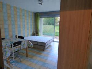 um quarto com uma cama, uma mesa e uma janela em Le Parc em Brioude