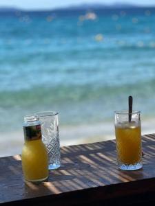 two glasses of orange juice sitting on a wooden table at Villa moderne 3 chambres double , proche de la mer, le Micocoulier quartier sainte Marguerite in La Garde