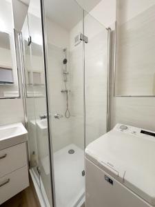 y baño blanco con ducha y aseo. en Apartmán Simcity Bratislava en Bratislava
