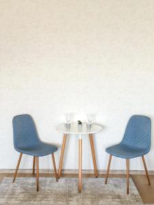 2 chaises et une table blanche avec 2 chaises dans l'établissement Apartmán Simcity Bratislava, à Bratislava