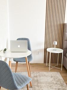 una sala de estar con una mesa y un ordenador portátil en una silla en Apartmán Simcity Bratislava en Bratislava