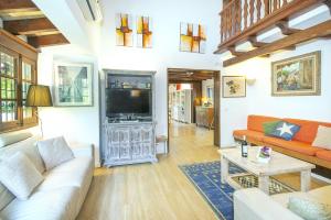 ein Wohnzimmer mit einem Sofa und einem TV in der Unterkunft Owl Booking Villa Can Francisco - Family and Friends in El Port