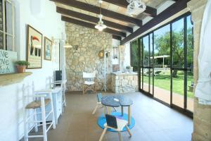 Zimmer mit einem Tisch, Stühlen und Fenstern in der Unterkunft Owl Booking Villa Can Francisco - Family and Friends in El Port