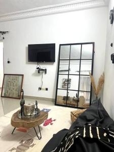 uma sala de estar com uma televisão e uma mesa de centro em 3 pièces moderne africain à 2min de la plage, à Fidjrosse em Cotonou
