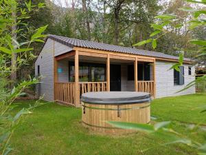 Cabaña pequeña con cenador en un patio en Camping La Marmotte en Savignac-les-Ormeaux