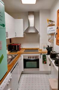 uma cozinha com armários brancos e um forno com placa de fogão em Casa El Tesorillo em Toledo