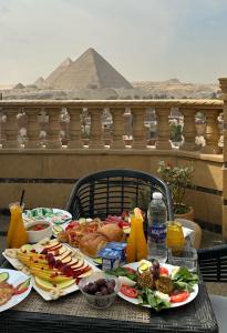 a table with plates of food on a table with a pyramid at Crowne Pyramids view inn in Cairo