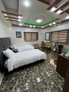 a bedroom with a large white bed and chairs at Petra balcony apartment in Wadi Musa
