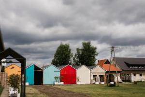 a row of colorful houses with a cloudy sky at Ceglarnia in Książ Wielkopolski