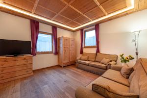 a living room with a couch and a flat screen tv at Agriturismo Apartments Tuene in Ortisei