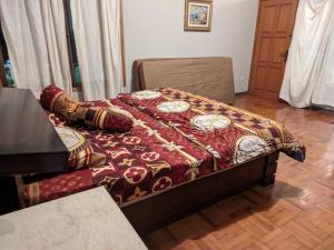 ein Schlafzimmer mit einem Bett mit einer Decke darauf in der Unterkunft Villa batu malang swimming pool in Batu
