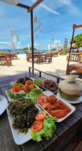 a table with plates of food on a beach at Lipe Beach Resort in Ko Lipe