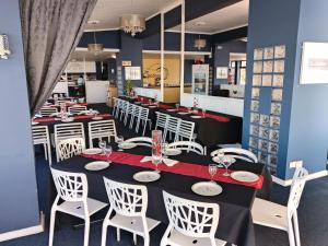 a dining room with tables and white chairs at Hoedjiesbaai Hotel in Saldanha