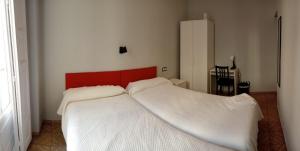 a bedroom with two white beds with a red headboard at Hostal Yolanda in Madrid