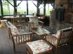un patio con mesas y sillas de madera y chimenea en AlleGorło, en Stare Juchy
