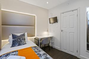 a hotel room with a bed and a desk at Single Studio Flat in London