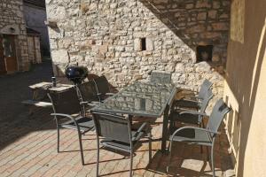 a table and chairs in front of a stone wall at Les Gites de Louisette Le 974 in Ébreuil
