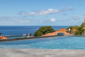 a swimming pool with a view of the ocean at Atlântico Azul in Funchal