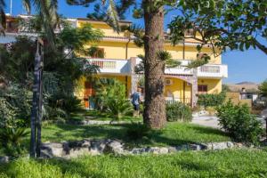 a man standing in front of a yellow building at Casa Cosmano in Brancaleone Marina