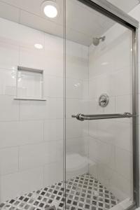 a shower with a glass door and a tile floor at East Beach Villa Unit 204 in East End +12 photos