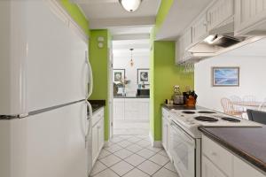 a kitchen with white appliances and green walls at East Beach Villa Unit 204 in East End