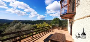 a balcony with a wooden bench and a view of the mountains at LA KASONA in Córdoba