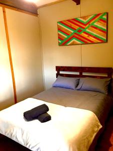 a bedroom with two beds and a towel on the bed at Pura Vida Forest Cabin in Witelsbos