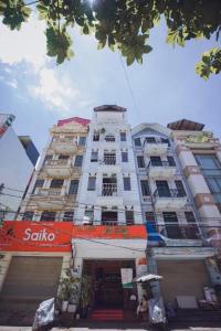 a tall white building with an orange sign on it at A25 Hotel - 45B Giảng Võ in Hanoi