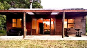 een klein houten huis met een tafel ervoor bij Pura Vida Forest Cabin in Witelsbos