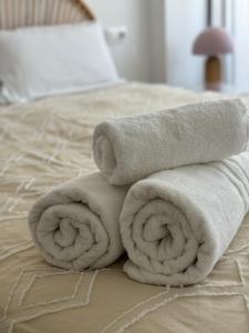 Una pila de toallas encima de una cama en Apartamento La Calma a 2 pasos de la playa, en Denia