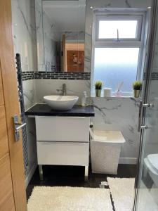 ein weißes Badezimmer mit einem Waschbecken und einem Spiegel in der Unterkunft NISHAT & AMAAN in Broadwater