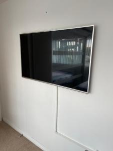 TV de pantalla plana en una pared blanca en NISHAT & AMAAN en Broadwater