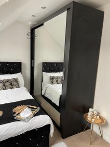 1 Schlafzimmer mit 2 Betten und einem großen Spiegel in der Unterkunft NISHAT & AMAAN in Broadwater