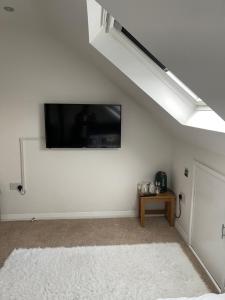 NISHAT & AMAAN في Broadwater: غرفة معيشة مع تلفزيون بشاشة مسطحة على جدار أبيض