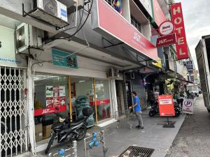 une personne qui passe devant un magasin dans une rue de la ville dans l'établissement EXPRESS OYO HOTEL, à Kuala Lumpur