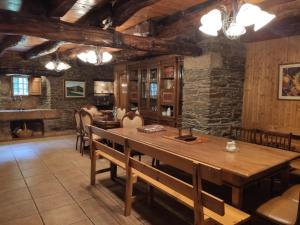 ein Esszimmer mit einem Holztisch und einer Steinmauer in der Unterkunft Casa Moucheiro in Lugo