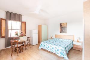 una camera da letto con un letto, un tavolo e delle sedie di Centro Vacanze Piccolo Friuli a Vieste