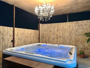 a large bath tub in a room with a chandelier at jacuzzi & spacious open terrace with room & bonfire in Gurgaon