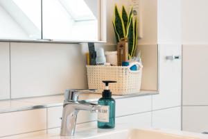 - un lavabo dans la salle de bains avec une bouteille de savon dans l'établissement Luxuswohnung am Steinhuder Meer - Tierfreundlich - C, à Wunstorf 17 autres photos