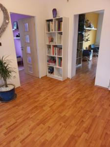 una sala de estar vacía con suelo de madera y estanterías en Paradise villa apartment, en Praga
