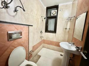 a bathroom with a toilet and a sink at jacuzzi & spacious open terrace with room & bonfire in Gurgaon