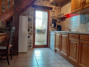 een keuken met een witte koelkast en een raam bij Gîte le MAGNAN, 55 m2, havre de paix, terrasse, jardin, piscine chauffée, sud Ardèche in Joyeuse